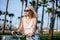 Joyful blonde woman riding bicycle in park having fun on summer afternoon