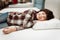 Joyful boy enjoying softness of orthopedic pillow rejoices in furniture store.