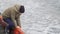 Joyful boy in hat and jacket plays with sea water waves