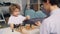 Joyful boy having fun with chess pieces while mom teaching him to play game