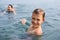 Joyful boy swims in the sea.