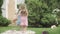 Joyful brunette twin sisters jumping with teddy bear on backyard. Wide shot portrait of cheerful Caucasian girls having