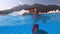 Joyful and carefree vacationer girl splashing water in the pool