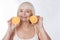 Joyful charming woman holding orange halves