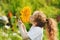 Joyful child smell sunflower enjoying nature in summer sunny day