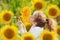 Joyful child smell sunflower in summer sunny day.