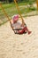 Joyful child swings on a swing in the summer season