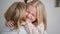 joyful childhood, adorable female child hugs her loving mom tightly during family vacation at home, close-up