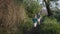 Joyful childhood, male children loving an active lifestyle run along path among green trees near river bank