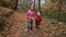 Joyful children running through autumn woodland