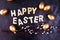 Joyful colorful spring background for a Happy easter with seasonal greeting text with rustic letter with flowers and tulips