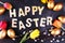 Joyful colorful spring background for a Happy easter with seasonal greeting text with rustic letter with flowers and tulips