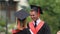 Joyful couple in academic dresses hugging and laughing, happy future, education