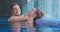 Joyful couple communicates in swimming pool water closeup