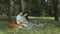 Joyful couple expecting baby picnicking in park