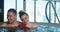 Joyful couple laughs and hugs sitting in whirlpool water