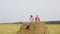 Joyful Couple Teens Jump Haystack Field Summertime