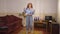 Joyful dance of happy retro woman indoors at home in slow motion. Wide shot portrait cheerful Caucasian redhead lady