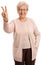 Joyful elderly woman making a victory sign