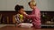 Joyful elementary age multiethnic girl and grandmother playing with doll at home