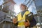 Joyful factory worker holding cup of coffee and documents