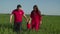 Joyful family with baby girl relaxing in wheat field