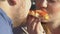 Joyful fat couple eating pizza slice with great appetite, fast food, close-up