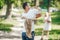 Joyful father and lovely daughter outdoor activity. Happy father holds his adorable baby headfirst in summer park