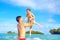 Joyful father and son having fun in water on tropical beach