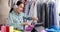 Joyful female fashion designer holding scissors at workplace in atelier