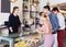 Joyful female helping customers to choose sweets