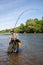 Joyful fisherman pulls caught salmon