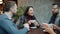 Joyful friends male and female talking and drinking coffee at table in cafe