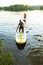 Joyful friends paddling on a SUP boards to the shore