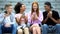 Joyful friends smartphones sitting campus stairs together, digital generation