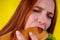 Joyful funny redhaired ginger girl with wild eyes suffering from anarexia with greedy ,eating large sandwic in studio