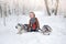 The joyful girl with dogs huskies in beautiful to the snow wood. Sit in snow and pose on the camera. Trees in snow