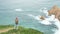 joyful girl photographer takes picture of ocean from cliff