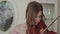 Joyful girl plays on violin with enthusiasm and harmony at camera