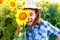 Joyful girl with sunflowers and closed eyes showing tongue