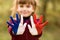 Joyful girl waving hands painted in France flag colors and say hello outdoor at sunset