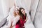 Joyful girls sitting on bed and laughing. Indoor shot of beautiful relaxed ladies in pajamas..