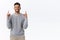 Joyful good-looking eastern male moden in grey sweater, pointing up, introduce promo, advertise corporate banner