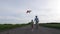 Joyful grandpa with grandson flying kite outdoor