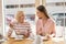 Joyful granny and granddaughter talking while having lunch