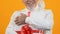 Joyful grey beard male holding present box with red ribbon, gift happiness