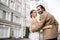 joyful groom in beige suit hugging