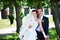 Joyful groom and bride in park