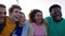 Joyful group of diverse student friends laughing together outside.