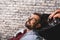 Joyful guy getting hairwash at barbershop